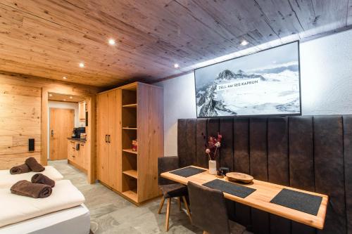 a dining room with a table and a tv on the wall at The VIEW - KAPRUN in Kaprun