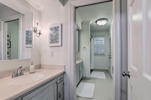 a white bathroom with a sink and a mirror at Central Thomasville Condo - Walk to Broad St! in Thomasville