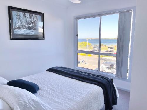 Un pat sau paturi într-o cameră la Marina Reflections