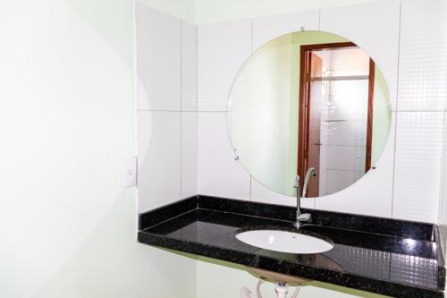 a bathroom with a sink and a mirror at Pousada Estrela da manhã in São Miguel do Gostoso