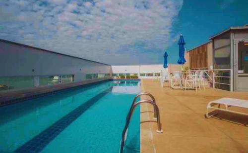 Bazén v ubytování FLAT exclusivo no Hotel RAMADA Macaé, Smartv, Wifi 512Mbps, piscina e Garagem nebo v jeho okolí