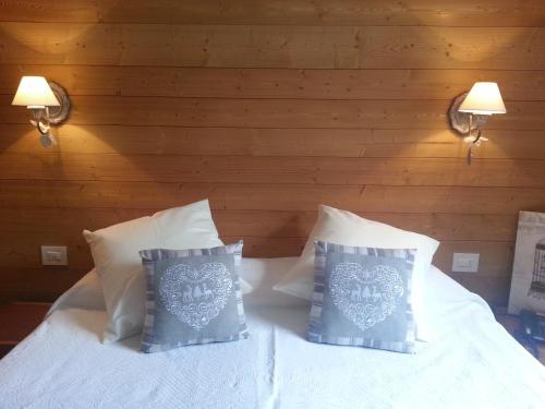 a bedroom with two beds with white sheets and pillows at Hotel Pedretti in Branzi