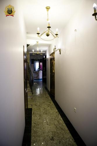 a hallway with a white wall and a chandelier at Rezydencja Bakamus in Sandomierz