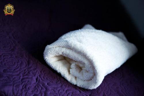 a white towel sitting on top of a purple bed at Rezydencja Bakamus in Sandomierz