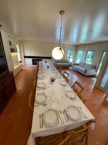 a long table with plates and silverware on it at 70's wood house in Maia