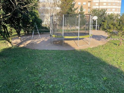 a playground with a trampoline in a park at 70's wood house in Maia
