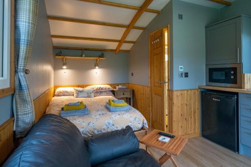 - une chambre avec un lit et un canapé dans l'établissement The Elm Shepod - Smardale Mill, à Smardale