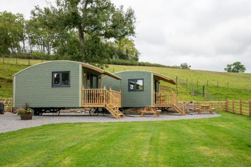 a green tiny house in a field with a yard at The Elm Shepod - Smardale Mill in Smardale