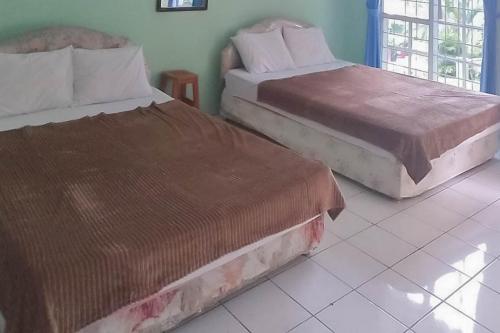 two beds sitting next to each other in a room at Villa Getsemani Mitra RedDoorz in Sangkanurip