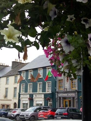 a blue building with cars parked in front of it at The Gateway Hotel in Swinford