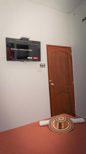 a room with a bed with a wooden door and a hat at Hotel Casa Martina Valledupar in Valledupar