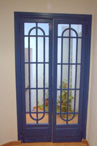 a blue cabinet with two windows in a room at Las Coles Apartasuites in Xàtiva