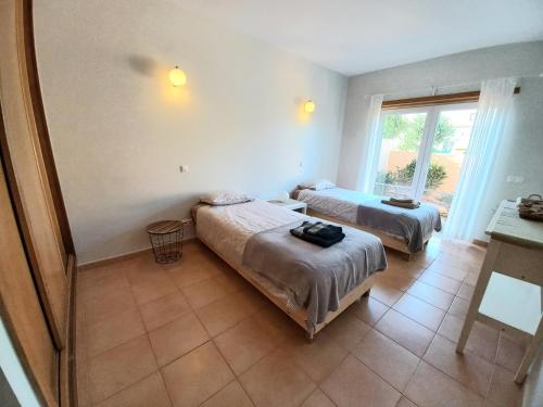a room with two beds and a window at Casa da Praia in Sagres