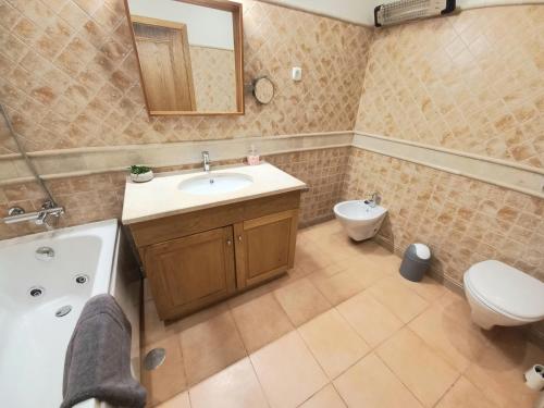 a bathroom with a sink and a tub and a toilet at Casa da Praia in Sagres