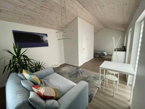 ein Wohnzimmer mit einem Sofa und einem Tisch in der Unterkunft ROKO house in Anykščiai