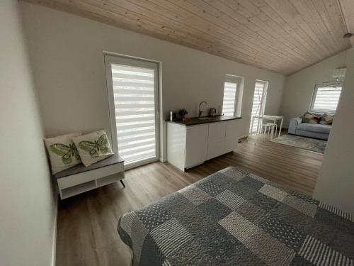 ein Schlafzimmer mit einem Bett und ein Zimmer mit einem Tisch in der Unterkunft ROKO house in Anykščiai