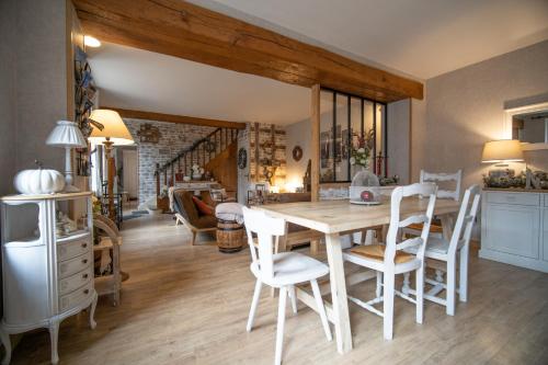 kuchnia i jadalnia ze stołem i krzesłami w obiekcie Entre Loire et Sologne Maison d'hôtes w mieście Saint-Gervais-la-Forêt