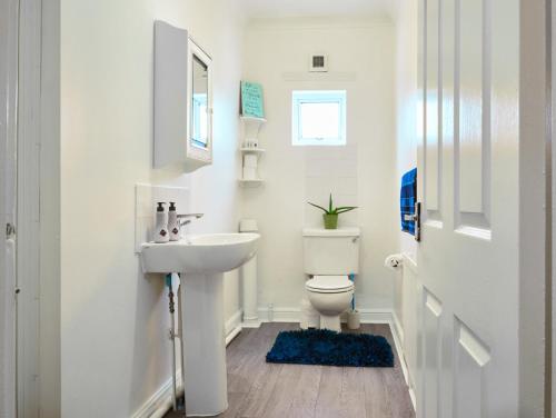 a white bathroom with a sink and a toilet at Graceful Home Away Sittingbourne in Sittingbourne