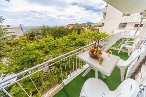 a balcony with a table and a bowl of fruit at Apartmani Steni in Sveti Stefan