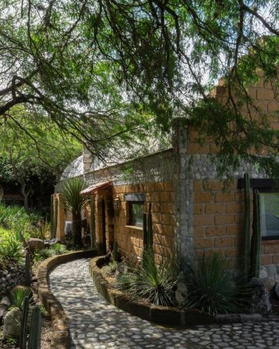 a brick house with a walkway in front of it at Armadillo Mágico in Armadillo