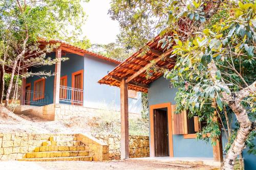 a blue house with stairs in front of it at Chalé aconchegante com Wi-Fi no Vale do Capão - BA in Vale do Capao