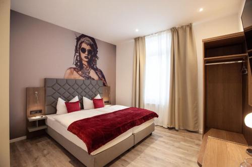 a bedroom with a bed with a large painting on the wall at Gästehaus freches Perlhuhn in Blumenthal