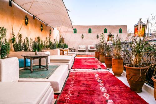 a room with a red carpet and potted plants at Riad Nouceiba Marrakech in Marrakech