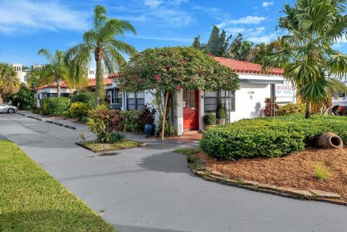 ein Haus mit einer roten Tür und einigen Büschen in der Unterkunft Oasis Hotel in Fort Lauderdale