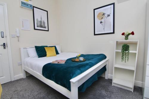 una camera da letto con un letto con una coperta blu sopra di Cute Studio 4 mins Walk To Planet Ice, Sleeps 3 a Coventry