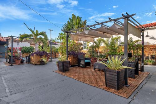 a patio with a lot of potted plants and a pergola at Oasis Hotel in Fort Lauderdale