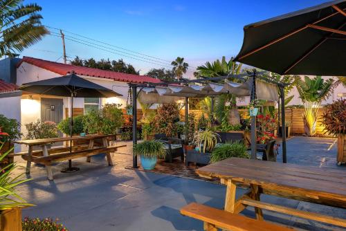 a patio with benches and umbrellas and plants at Oasis Hotel in Fort Lauderdale