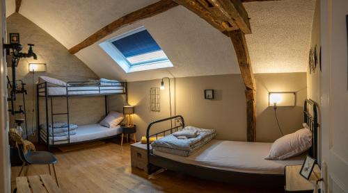 een kamer met 2 stapelbedden en een dakraam bij Entre Loire et Sologne Maison d'hôtes in Saint-Gervais-la-Forêt