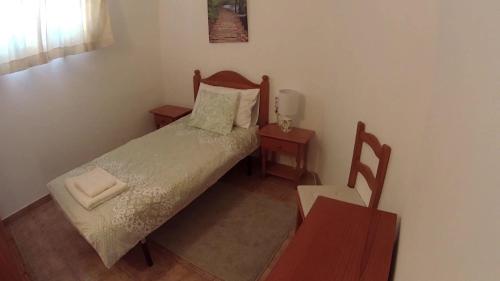 a small bedroom with a bed and two tables at Verde casa eden in Tías