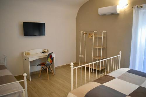 - une chambre avec un lit, un bureau et une télévision dans l'établissement Dimora normanna, à Aversa