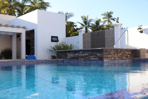 a swimming pool in front of a villa at Mar Sol Bungalows & Hotel in Mazatlán