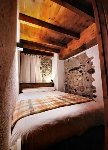 a bed in a room with a wooden ceiling at Apartamento Gerbille in Bourg-Madame