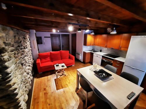 ein Wohnzimmer mit einem roten Sofa und einer Küche in der Unterkunft Apartamento Gerbille in Bourg-Madame