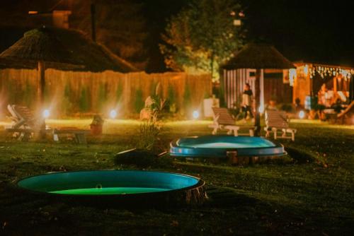 two trays in front of a fountain at night at Aloha Glamp - okrągłe domki przy rzece - balia i sauna - Energylandia in Zagórnik
