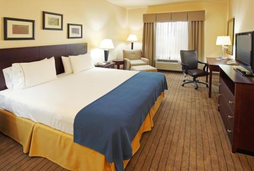 Habitación de hotel con cama grande y escritorio. en Holiday Inn Express Hotel & Suites Marshall, an IHG Hotel en Marshall