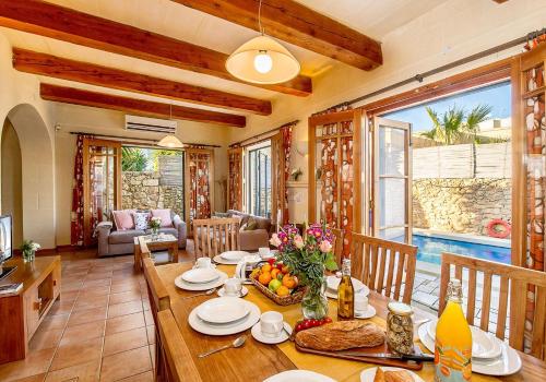 a living room with a wooden table and a dining room at Casetta Menzja Semi Detached Bungalow in Sannat