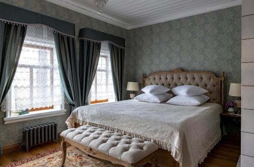a bedroom with a large bed with white pillows at Бутик-отель Пестово подворье in Suzdal