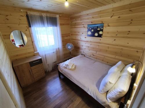 1 dormitorio con 1 cama en una habitación de madera en База отдыха NaVolgo на Селигере en Zavir'ye