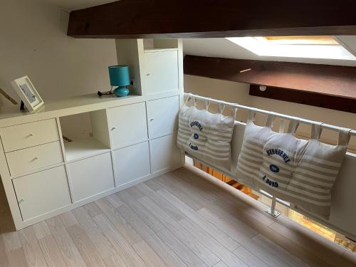 a room with white cabinets and a shelf with towels at LES MIMOSAS in Saint-Trojan-les-Bains