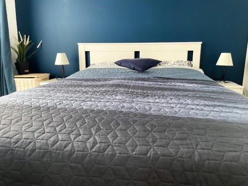 um quarto com uma cama grande e uma parede azul em Feels like home JUAN FLORE - Air-conditioned furnished apartment with terrace & parking em Antibes