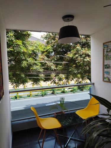 Habitación con 2 sillas amarillas y ventana en Hotel Aura Medellin, en Medellín