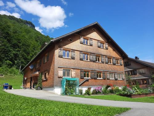 a large brick building with windows on a hill at Haus Dekker in Mellau