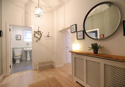 ein Badezimmer mit einem Spiegel, einem Waschbecken und einem WC in der Unterkunft The Old Bakery in Edinburgh