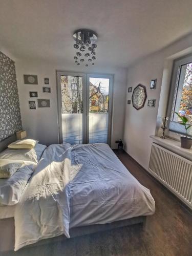 a bedroom with two beds and two windows at Apartament W SERCU USTRONIA in Ustroń