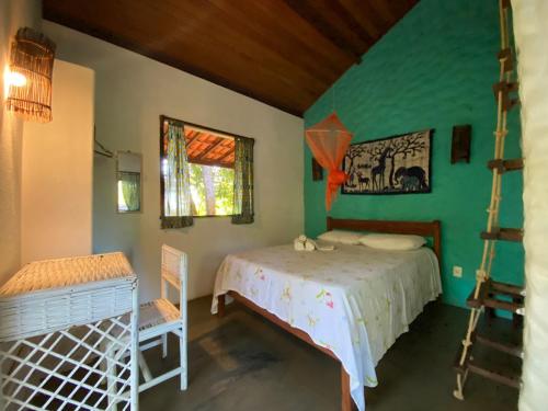 1 dormitorio con cama y pared verde en Casa Mestiça, en Isla de Boipeba