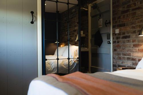 a reflection of a bed in a room with a mirror at The Old Hall Inn in Chinley